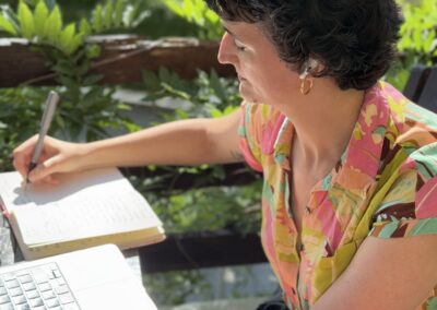Judit Saez writing in a notebook while working outdoors